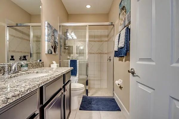Second guest bathroom with walk-in glass shower, single vanity, dark cabinets