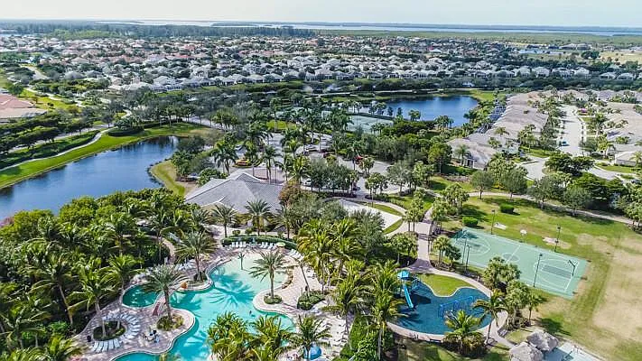 Aerial drone view of Sandoval community — resort pool, sports courts, lakes, and homes
