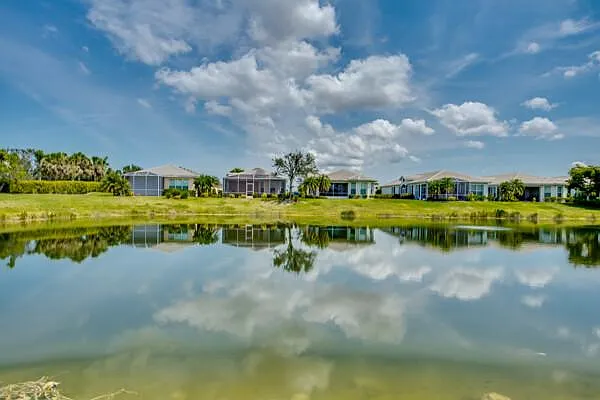 Sandoval community lake from across the water — homes reflected in calm water