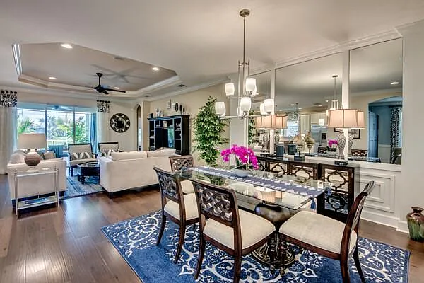 Dining and living rooms open plan — chandelier, blue rug, beige sofas