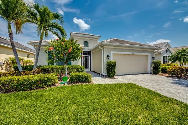 Front exterior of 2649 Casibari Ct — paver driveway, palm trees, 2-car garage