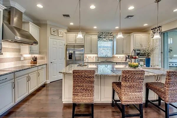 Outdoor bar counter with granite top, pendant chandelier, and bar stools