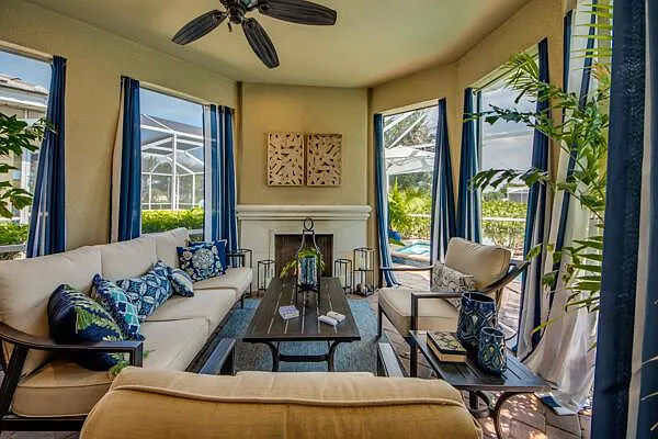 Lanai fireplace and sofa seating — alternate angle showing pool and palms
