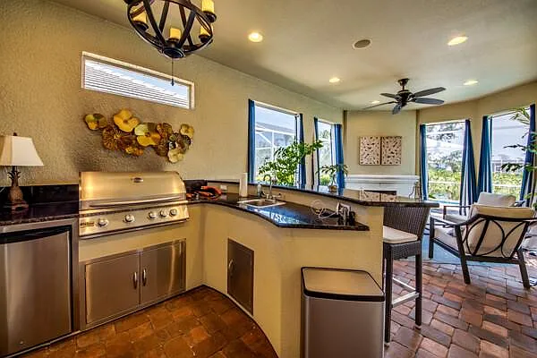 Outdoor grill and bar — gas grill with dark granite countertop beside the pool