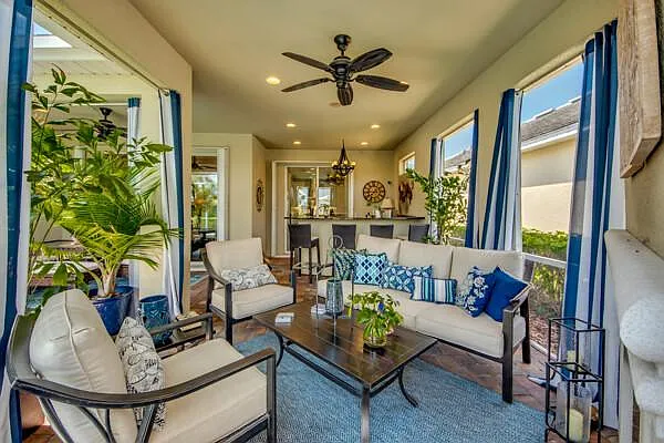 Lanai lounge seating with blue curtains and outdoor bar visible in background