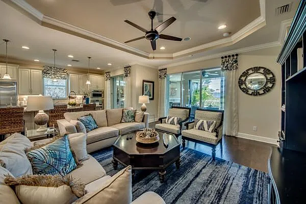 L-shaped beige sofa in living room open to kitchen island — alternate angle
