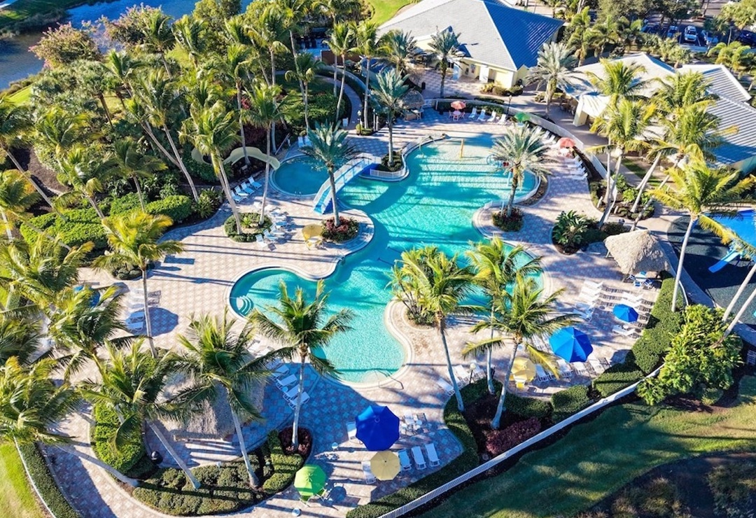 Sandoval lagoon resort pool with tiki huts and palm-lined lake backdrop