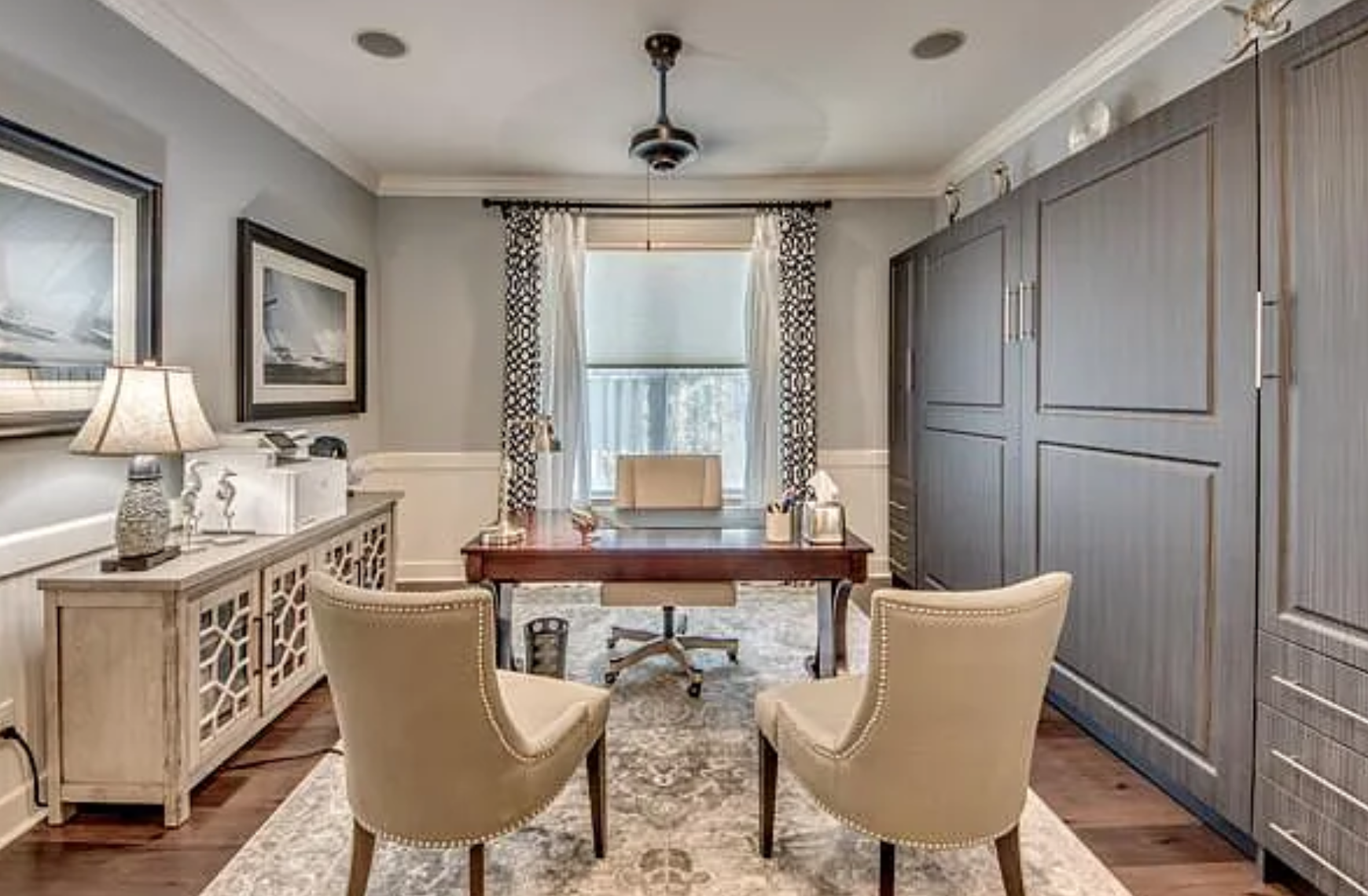Elegant home office / den with wood-tone built-ins and natural light